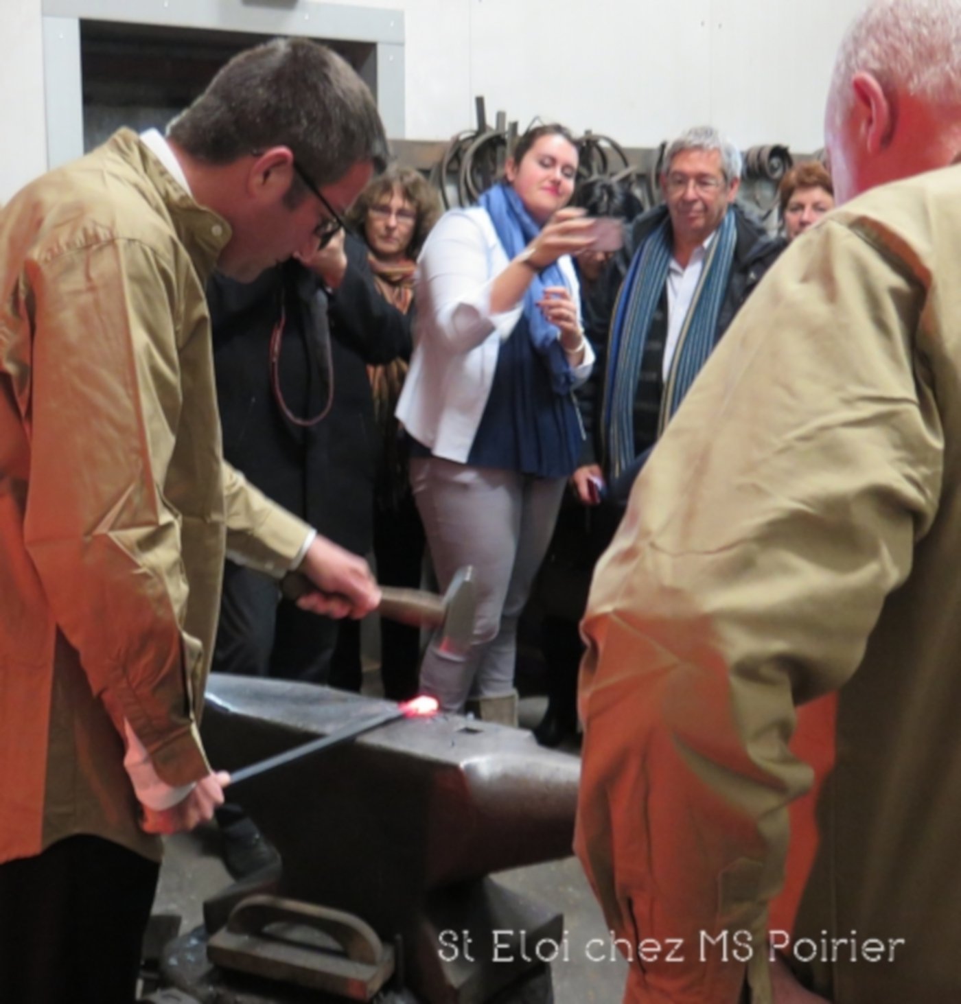 Karl Olive donne des coups de marteau sur un fer rouge